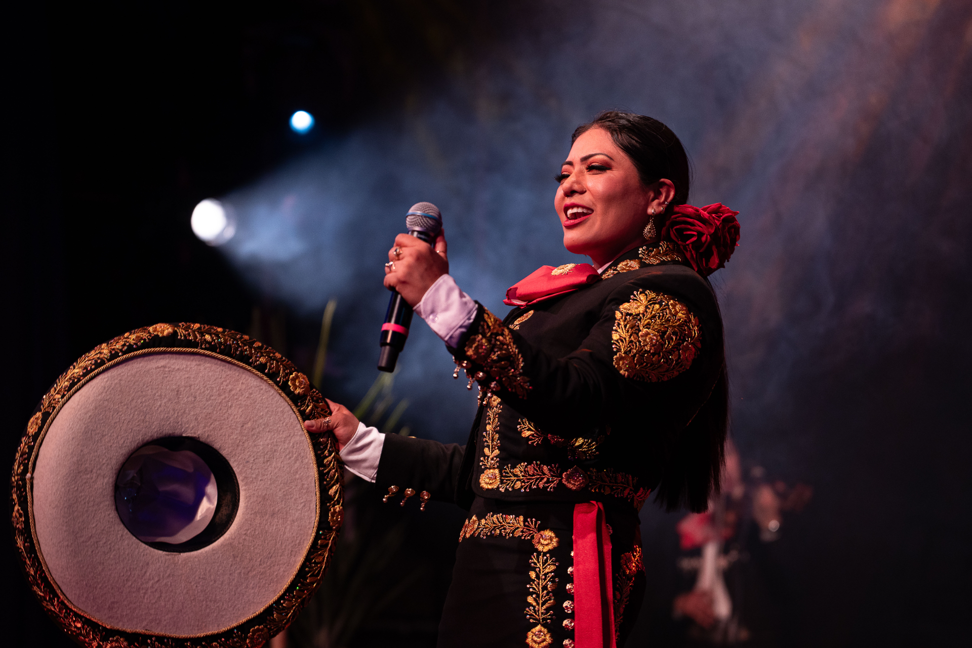 Rosario del Valle sonriendo mientras canta con traje de charra