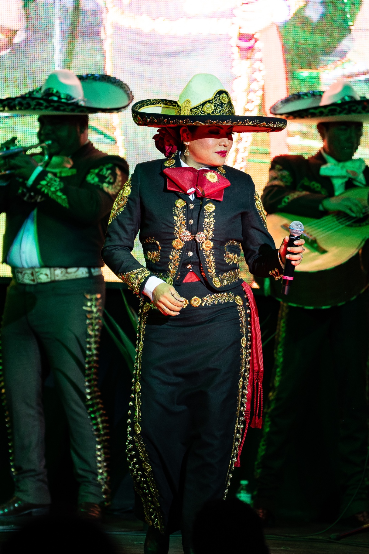 Rosario del Valle con traje de charra y sombrero junto al mariachi